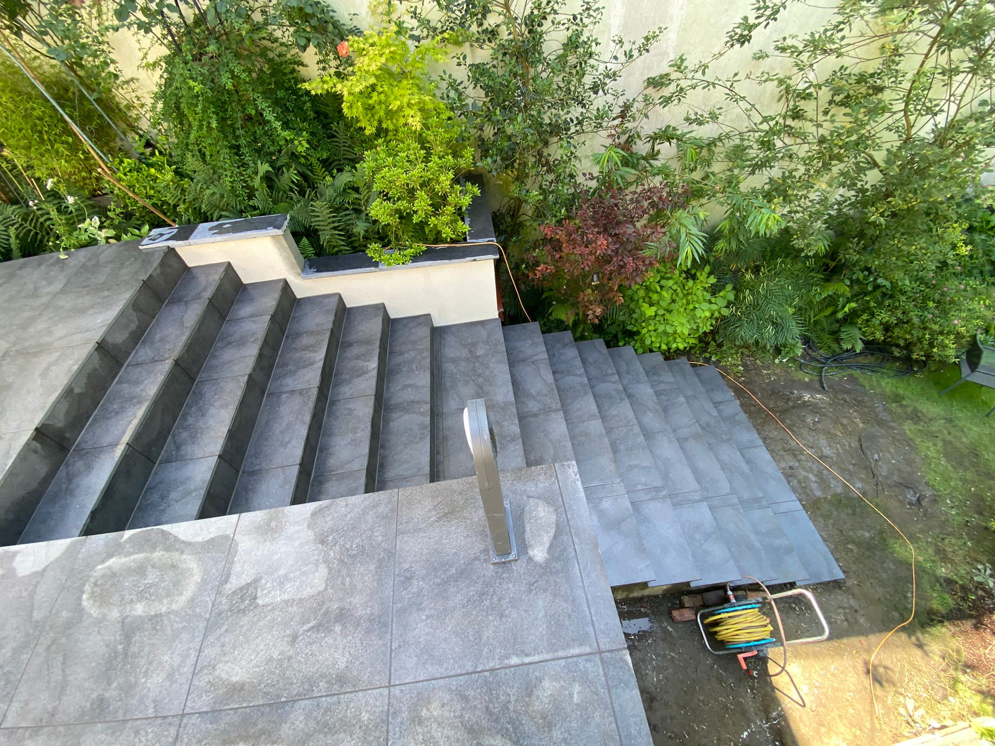 Terrasse et escalier extérieurs en carrelage anthracite réalisés par Lotus Construct